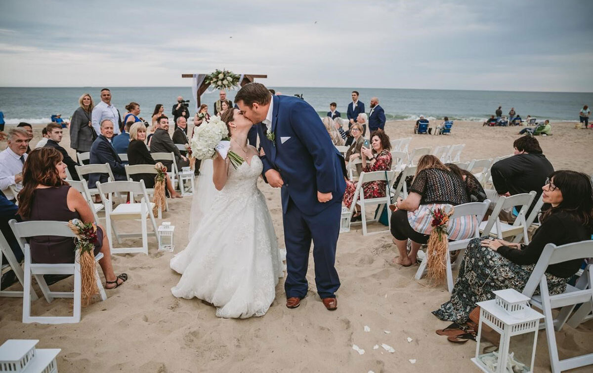 young man and woman just married on the beach