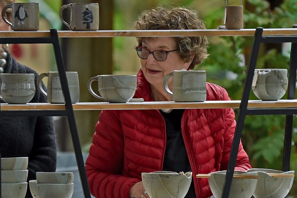 woman looking at pottery at a craft fair